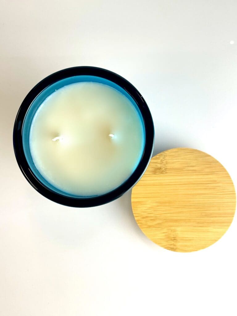 Summertime Somewhere soy coconut wax candle in a blue glass jar with a wooden lid, hand-poured by 95indies in Evans, GA.