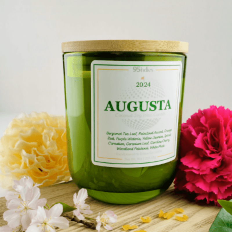 The 2024 Augusta Candle in a green glass tumbler with a bamboo lid, hand-poured soy-coconut wax blend.
