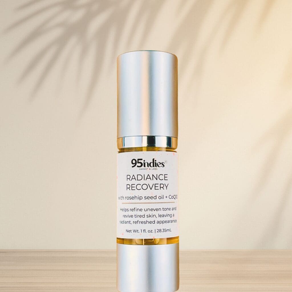 95indies Radiance Recovery oil bottle with palm shadows on neutral background