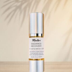 95indies Radiance Recovery oil bottle with palm shadows on neutral background