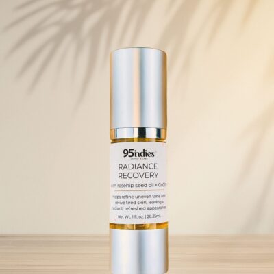 95indies Radiance Recovery oil bottle with palm shadows on neutral background