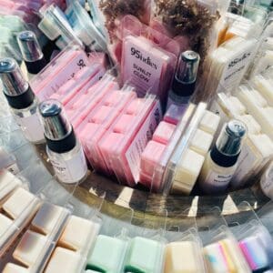 Assorted 95indies hand-poured soy wax melts displayed alongside other home fragrance items in a round basket.