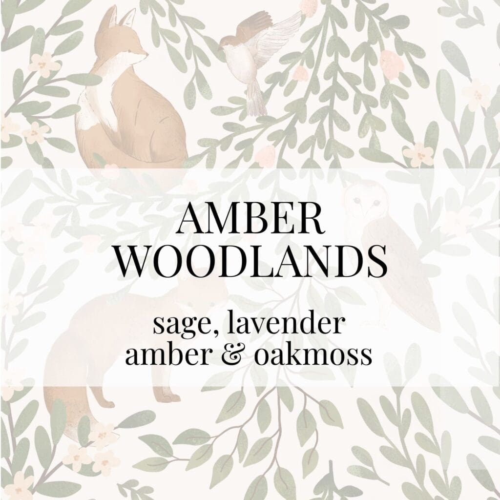 A watercolor illustration of woodland animals, including a fox and an owl, among leaves. A text overlay reads "AMBER WOODLANDS" and lists the fragrance notes.